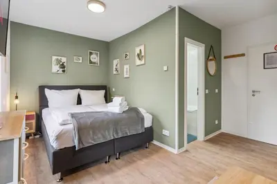 Ein Bett oder Betten in einem Zimmer der Unterkunft Vorstadtoase - 3 Personen - Apartment mit Queensize-Bett, Badewanne, Schlafcouch, Parken, Netflix, Nähe BER