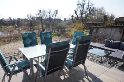 Ein Balkon oder eine Terrasse in der Unterkunft FeWo EG am Fluss mit Terrasse - eine grüne Oase
