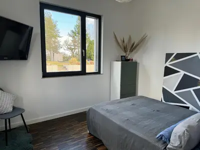 Ein Bett oder Betten in einem Zimmer der Unterkunft helle Ferienwohnung in Architektenhaus mit Garten und Pool