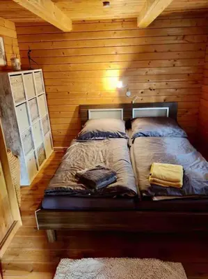 Ein Bett oder Betten in einem Zimmer der Unterkunft FEWO PARTNERS Haus Clemens - Gemütliches Holzhaus mit Grundstück nahe Badesee