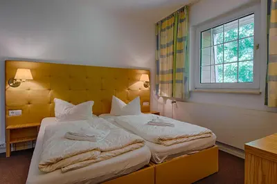Ein Bett oder Betten in einem Zimmer der Unterkunft See Hotel Karlslust Chalets