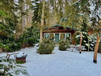 Holzhaus Bärenhöhle am Wald und See im Winter
