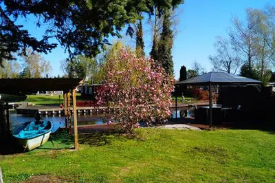 Ein Garten an der Unterkunft Ferienhäuschen direkt am Wasser inklusive 2 Boote