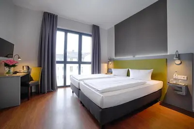 Ein Bett oder Betten in einem Zimmer der Unterkunft H+ Hotel 4Youth