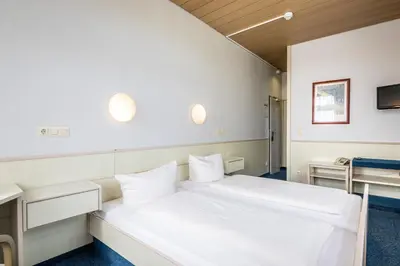 Ein Bett oder Betten in einem Zimmer der Unterkunft Hotel und Rasthof AVUS