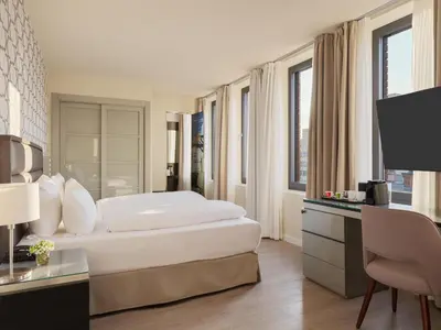 Ein Bett oder Betten in einem Zimmer der Unterkunft H10 Berlin Ku'Damm