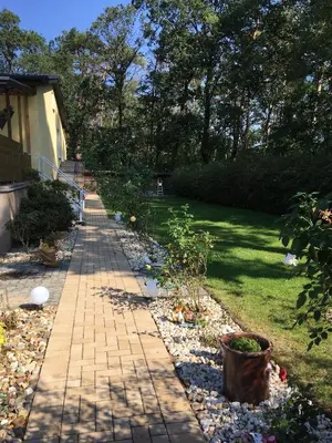 Ein Garten an der Unterkunft Helles Doppelzimmer im Untergeschoss mit Bad im Grünen nahe Potsdam