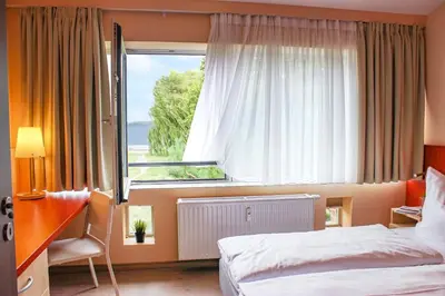 Ein Bett oder Betten in einem Zimmer der Unterkunft PRIMA Inn Ferienwohnungen Sonnenufer am Ruppiner See