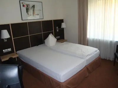 Ein Bett oder Betten in einem Zimmer der Unterkunft Hotel Landhaus Schlachtensee