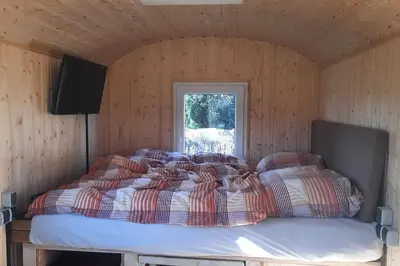 Ein Bett oder Betten in einem Zimmer der Unterkunft Zirkuswagen Glamping für 2 mit Veranda Küche Netflix Parken und Hofladen