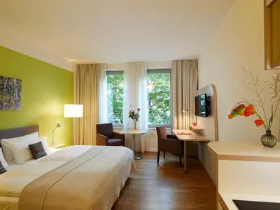 Ein Bett oder Betten in einem Zimmer der Unterkunft Flottwell Berlin Hotel & Residenz am Park